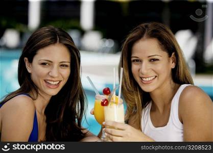 Close-up of two young women holding juice glasses