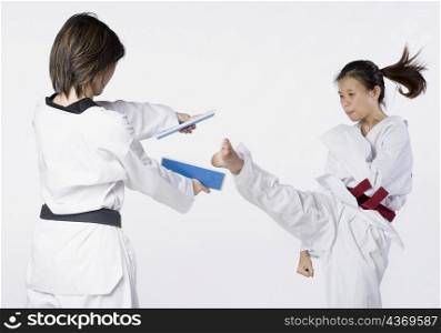 Close-up of two young women practicing kickboxing