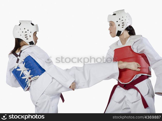 Close-up of two young women practicing kickboxing