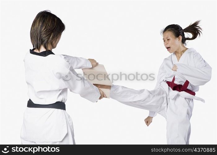 Close-up of two young women practicing kickboxing