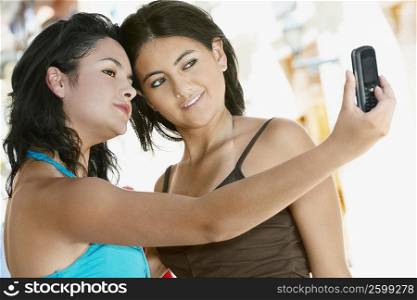 Close-up of two young women taking a photograph of themselves