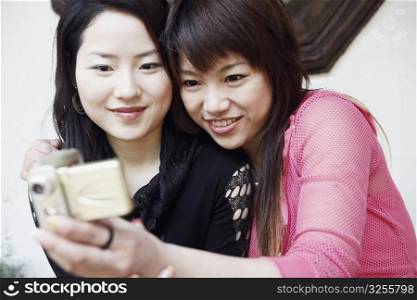 Close-up of two young women taking a photograph of themselves