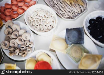 Close-up of uncooked assorted pastas and dumplings in trays