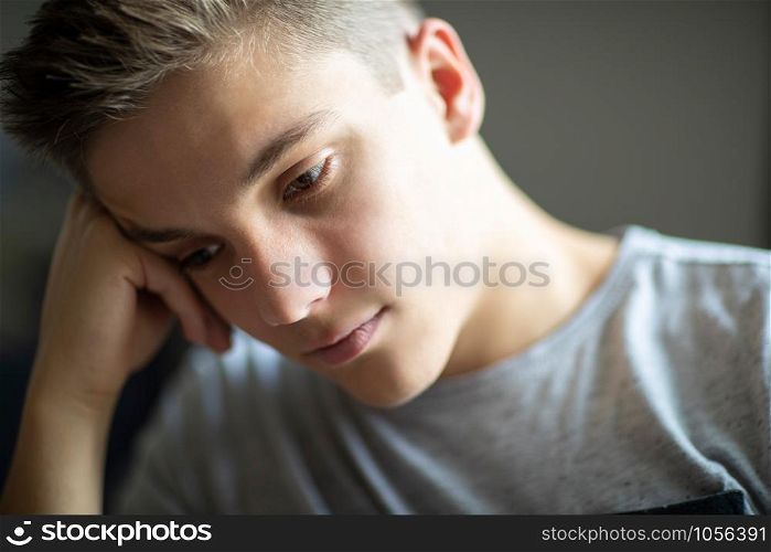 Close Up Of Unhappy And Depressed Teenage Boy At Home