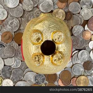 Close up of upside down piggy bank, focus on complete belly, with loose coins underneath. Concept of financial hard times. &#xA;&#xA;