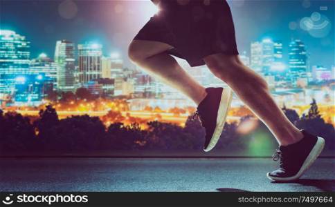 Close up of urban runner legs run on the night street .