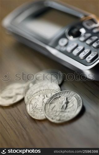 Close-up of US coins and a mobile phone on the table