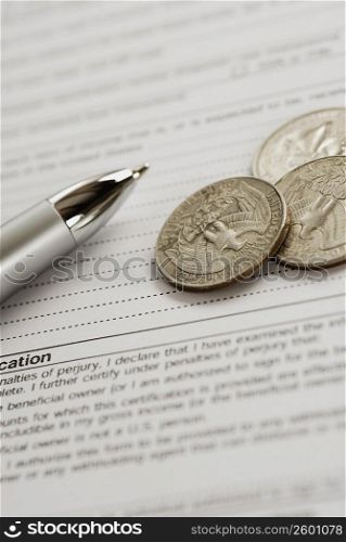 Close-up of US coins and a pen on a form
