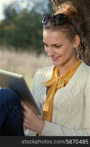 Close Up of using ipad young woman in the park. Touching touchscreen
