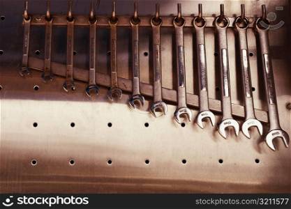 Close-up of various spanners hanging from hooks