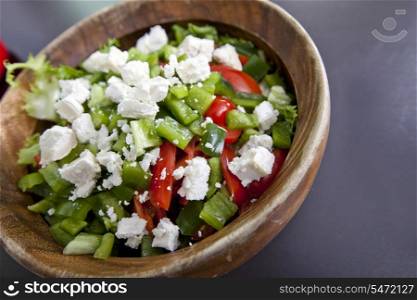 Close-up of vegetable salad in wooden bowl on counter