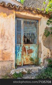 Close-up of very old grungy iron weathered door in Siranades on Corfu, Greece.