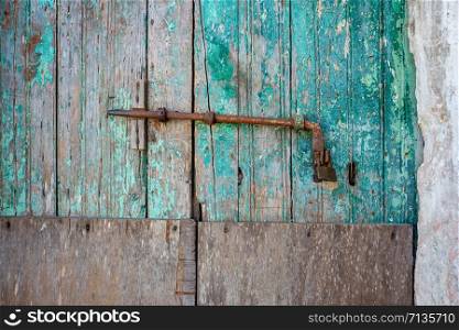 Close-up of very old grungy wooden weathered doors with door handle in Siranades on Corfu, Greece.