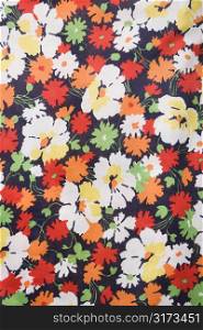 Close-up of vintage fabric with colorful flowers printed on polyester.