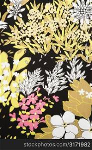 Close-up of vintage fabric with pattern of pink and golden flowers and leaves on polyester.