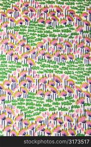 Close-up of vintage fabric with pink flowers and green fish printed on polyester.