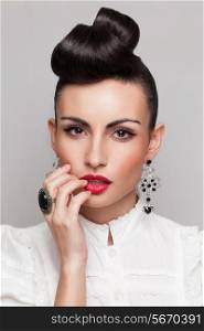 Close Up of vintage styling model with makeup and updo. accessories. Red lips. White lacy shirt