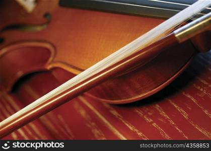Close-up of violin and violin bow on wooden table