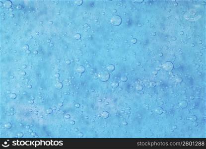 Close-up of water drops on a blue surface