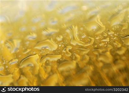 Close-up of water drops on a yellow surface