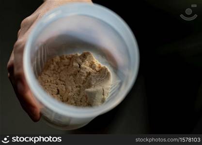 Close up of whey protein and bottle preparing protein shake.