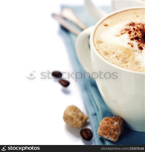 Close-up of white cup of coffee with blue napkin