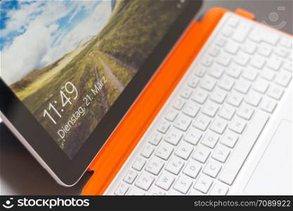 Close-up of white orange convertible laptop and keyboard