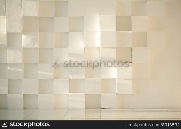 Close-up of white painted concrete modern wall made of cubes with tiled floor. White painted concrete wall made of cubes with tiled floor