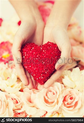 close up of woman&#39;s hands holding heart
