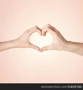 close-up of woman and man hands showing heart shape