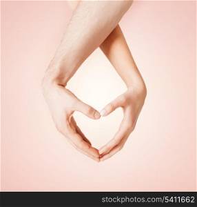 close up of woman and man hands showing heart shape