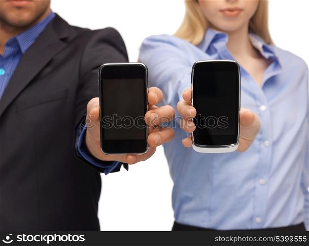close up of woman and man hands with smartphones