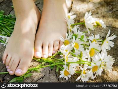 close up of woman feet with camomiles