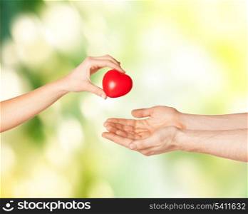 close up of woman hand giving heart to man