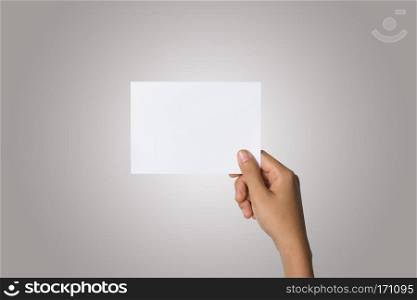 Close Up of woman hand holding blank paper isolated on white bac. Close Up of woman hand holding blank paper isolated on white background