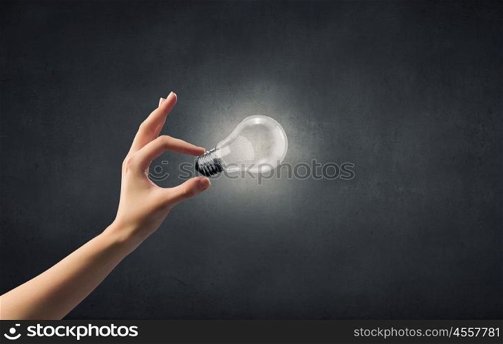 Close up of woman hand holding glass light bulb. Bulb in hand