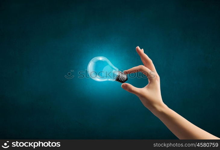 Close up of woman hand holding glass light bulb. Bulb in hand