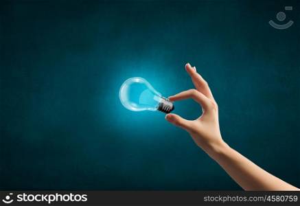 Close up of woman hand holding glass light bulb. Bulb in hand