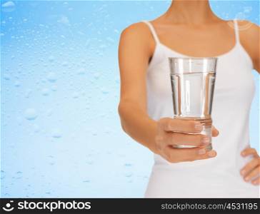 close up of woman hand holding glass of water over blue background. woman hand holding glass of water