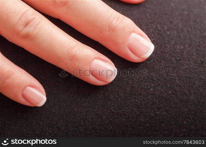 Close-up of woman hand with french manicure part of palm female fingers black background