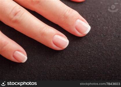 Close-up of woman hand with french manicure part of palm female fingers black background