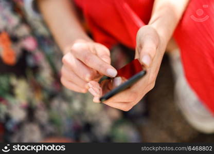 Close up of woman hands touching touch screen of a smart phone outdoors. Girl shopping in Internet.