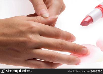 close up of woman hands with a red lipstick and pink petals of roses all around