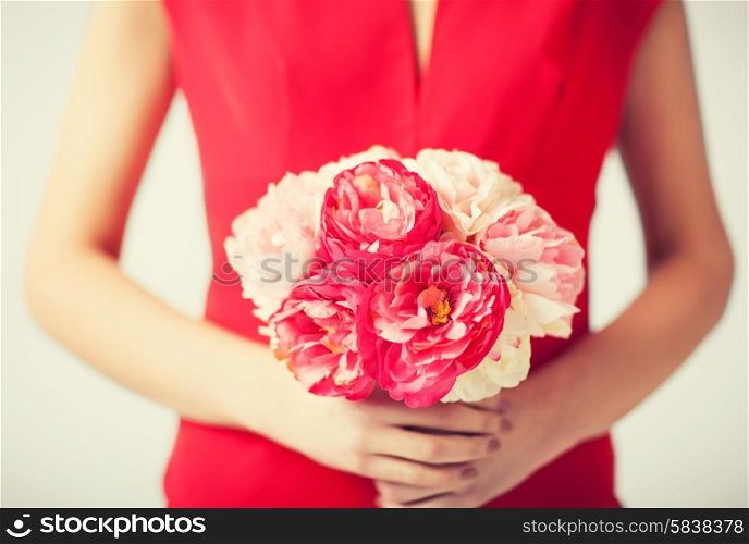 close up of woman hands with bouquet of flowers.