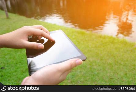 close up of Woman hands with tablet pc at a outdoors