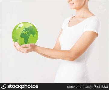 close up of woman holding green sphere globe
