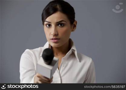 Close-up of woman holding microphone against colored background