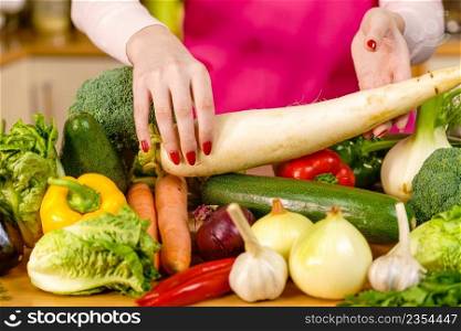 Close up of woman holding white raddish.Healthy lifestyle, dieting food, eating vegetables concept.. Woman hand holding white raddish