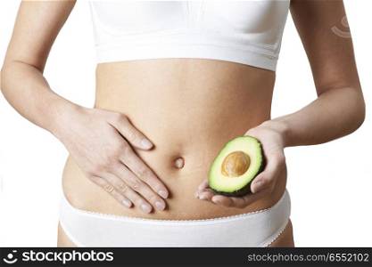 Close Up Of Woman In Underwear Holding Avocado And Touching Stomach