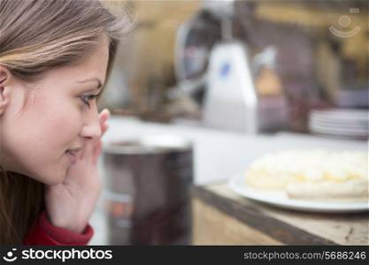 Close-up of woman looking at cake in cafe